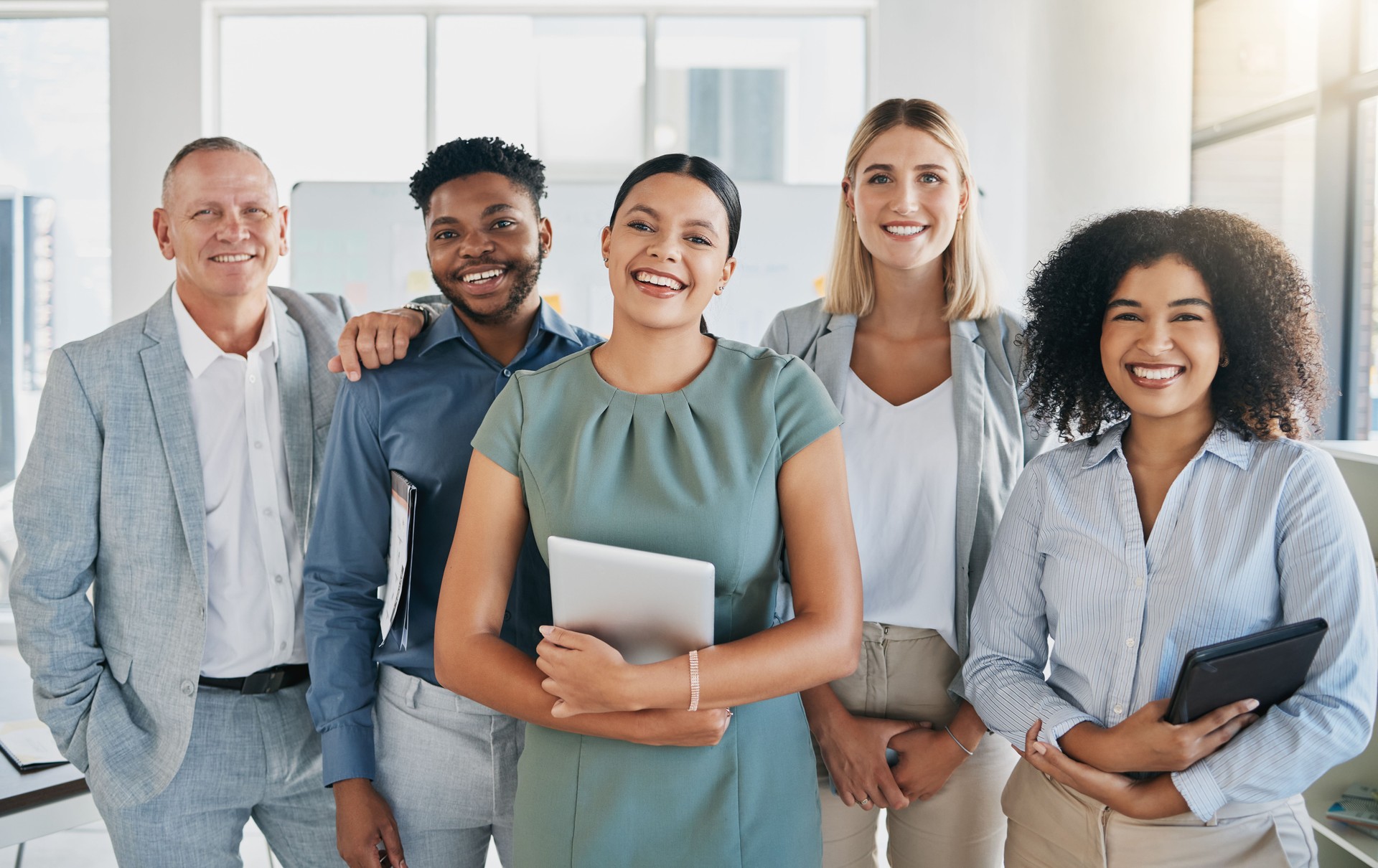 Portrait, happy or business people in a digital agency in an office building with motivation, goals or mission. Leadership, team work or confident employees smile with pride, solidarity or support